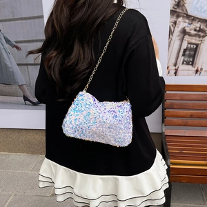 Sparkly white sequin crossbody bag with gold chain strap shown on a street style model