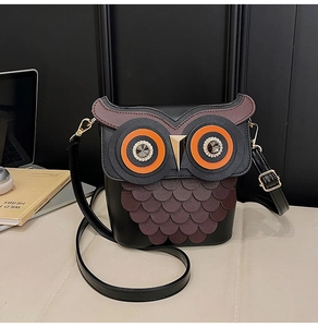 Detail of owl shaped crossbody bag featuring crystal eyes and scale texture details