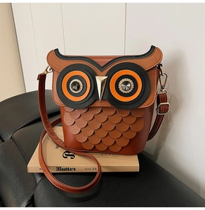 Detail of owl bucket bag with layered leather feathers and sparkling eye accents