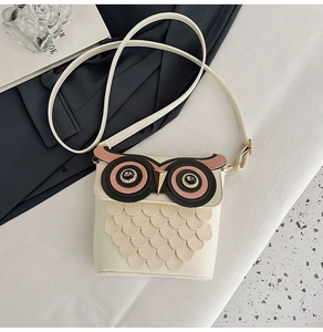 Detail of creative owl-shaped crossbody bag featuring textured feathers and metallic beak