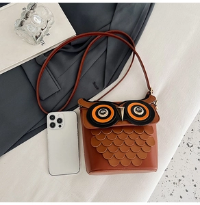 Detailed macro view of an owl-shaped crossbody bag showing layered feather texture