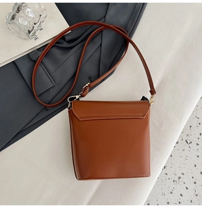 Detail of caramel brown leather shoulder bag with fine stitching and gold hardware