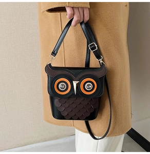 Detail of owl bucket bag showing layered leather scales and sparkling rhinestone eyes