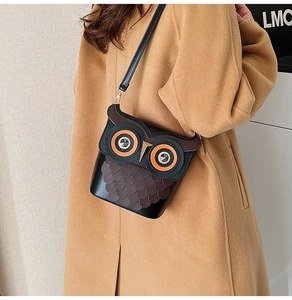 Detailed close-up of a whimsical owl-shaped crossbody bag with unique layered feather accents