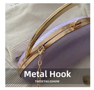 Detail shot of the golden metal lobster clasp and chain hook on a purple acrylic bag