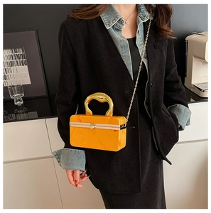 Detail of a bright yellow marble texture acrylic handbag with a gold curved handle