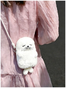 Detail view of a soft white plush seal-shaped crossbody bag with rope shoulder strap
