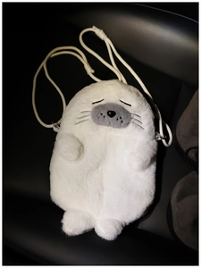 Detail of cute white seal plush crossbody bag with soft faux fur and embroidered closed eyes