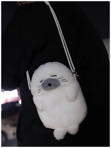 Detail of white plush seal crossbody bag with soft faux fur texture and adjustable strap