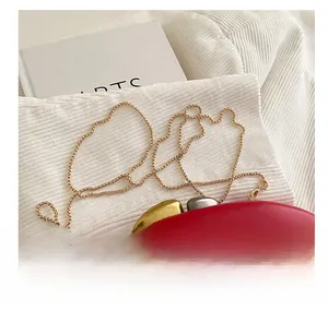 Detail of red matte leather bag with gold ring chain and dual-tone metal buckle closure