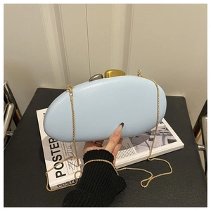 Detail of light blue pebbled leather evening clutch with artistic dual-tone metal buckle