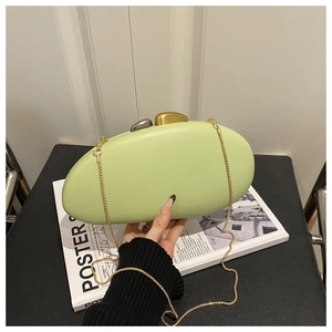 Detail of light green oval acrylic clutch bag with pebble clasp and gold chain strap
