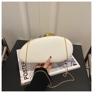Detail of white pebble-shaped acrylic clutch with asymmetric gold and silver metal buckles