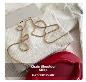 Detailed view of red fashion box bag with gold metal snake chain strap and U-shaped handle