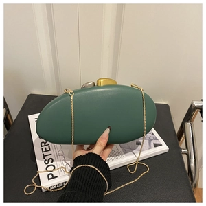 Detail of dark green acrylic evening clutch with unique gold and silver clasp and chain