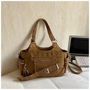 Close-up of brown suede bucket bag featuring metal eyelets and punk style zippers