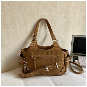 Detail view of retro brown moto tote bag with metal zippers and decorative buckle