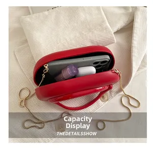 Interior view showing red oval box bag capacity for smartphone, lipstick and earphones