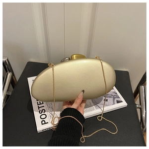 Detail of gold oval evening clutch with matte metal texture and pebble-shaped clasps
