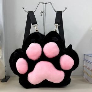 Detail of adjustable black fabric straps and gold metal hooks on plush paw backpack