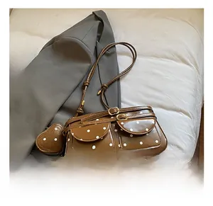 Vue détaillée d'un sac à bandoulière vintage à pois avec poches à rabat et breloque cœur