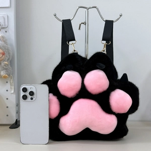 Size comparison of the plush cat paw backpack next to a smartphone showing scale
