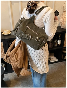 Detail of vintage olive green oversized bucket bag with punk rivets and metal zippers