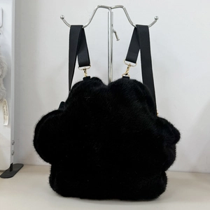 Detail of plush cat paw backpack showing soft black fur texture and golden metal hardware