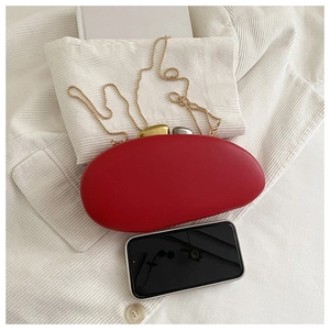 Detail view of red pebble evening clutch with dual-tone metal clasps and gold chain strap