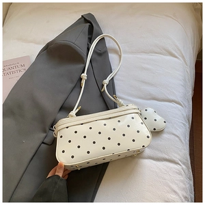 Détail du sac baguette rétro à pois avec son porte-monnaie en forme de cœur assorti