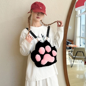 Detail of plush black cat paw bag with pink pads and adjustable nylon shoulder strap