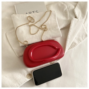 Detail of red acrylic mini bag with gold chain and phone for size comparison