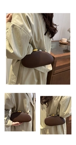 Detail view of brown pebble-shaped acrylic clutch with gold and silver metal clasp and chain