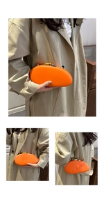 Detail showing bright orange pebble-shaped evening bag with gold-silver clasp and chain