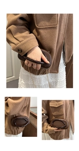 Detail of dark brown mini crossbody box bag featuring circular acrylic handle and gold chain
