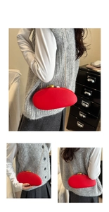 Detail of red oval acrylic PU clutch with gold chain and unique metallic clasp