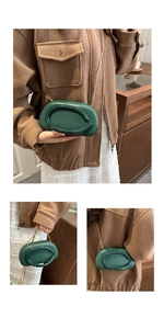Macro detail of dark green oval mini bag with gold chain strap and textured leather finish