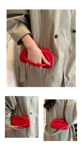 Detailed view of red acrylic box clutch with gold chain and unique puffy silhouette