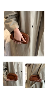 Detail of brown acrylic capsule crossbody bag with large circular handle and gold chain strap