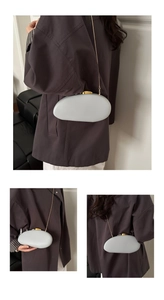 Detail view of a pebble-shaped acrylic PU clutch bag with a sleek gold chain shoulder strap