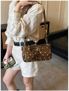 Détail du sac à bandoulière marron à pois avec charm en cœur et boucles métalliques