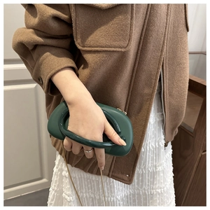 Detailed view of a dark green jelly-style acrylic clutch bag with a unique U-shaped handle