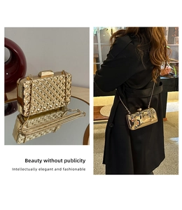 Detail der goldenen Hartschalen-Abendtasche mit Webstruktur und Kettenriemen