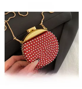 Dettaglio mini borsa da sera rossa con strass, borchie d'argento e catena d'oro
