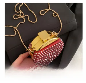 Dettaglio della mini borsa da sera con strass rossi, catena dorata e chiusura a scatto