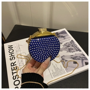Dettaglio della mini borsa da sera glitter blu con borchie e catena dorata