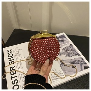 Dettaglio mini borsa da sera rossa con strass, borchie e sottile catena dorata