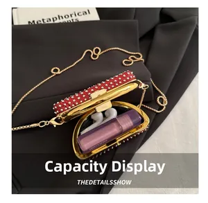 Detail showing red rhinestone clutch interior capacity for lipstick and wireless earphones