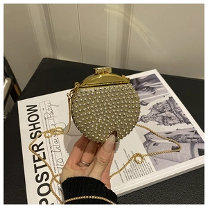 Dettaglio mini borsa da sera tonda con strass, catena dorata e chiusura in metallo