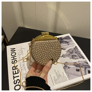 Dettaglio borsa da sera tonda dorata con strass e tracolla a catena